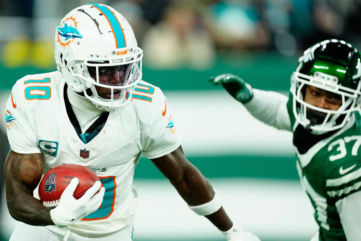 Miami Dolphins wide receiver Tyreek Hill (10) runs with the ball past New York Jets cornerback Qwan'tez Stiggers (37), Sunday January 5, 2025, in East Rutherford.