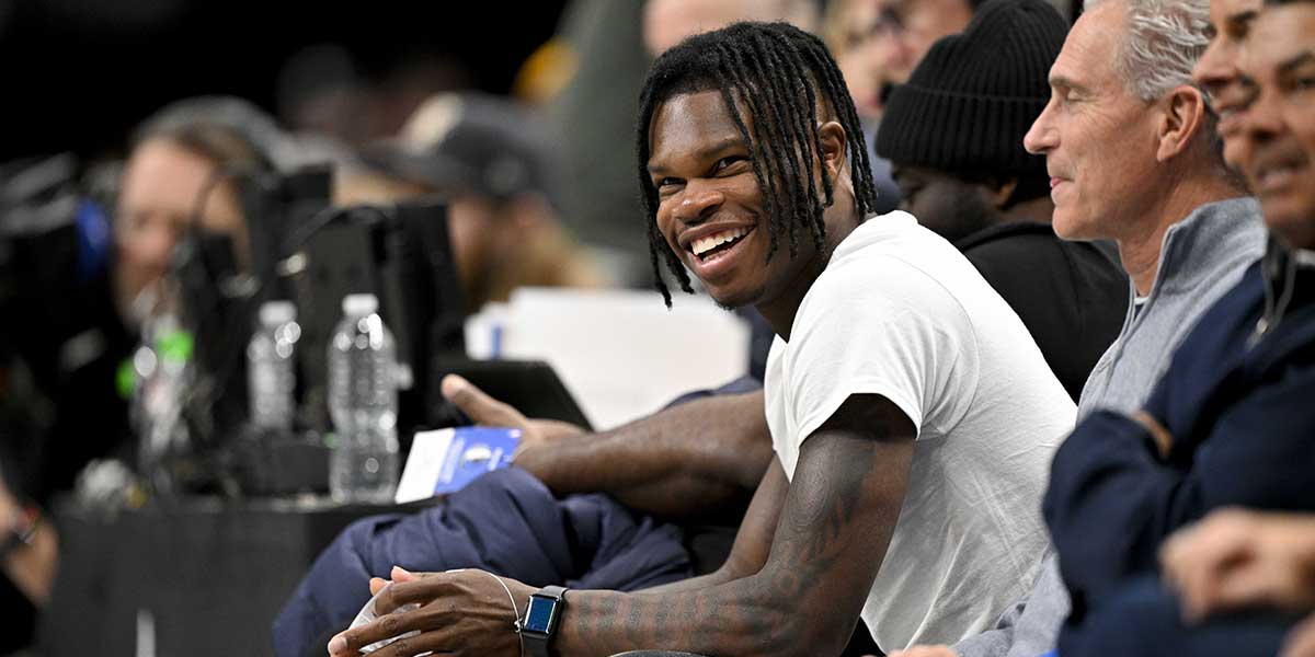 2024 Heisman Trophy winner Travis Hunter Jr. laughs during the second half of the game between the Dallas Mavericks and the Minnesota Timberwolves at the American Airlines Center.