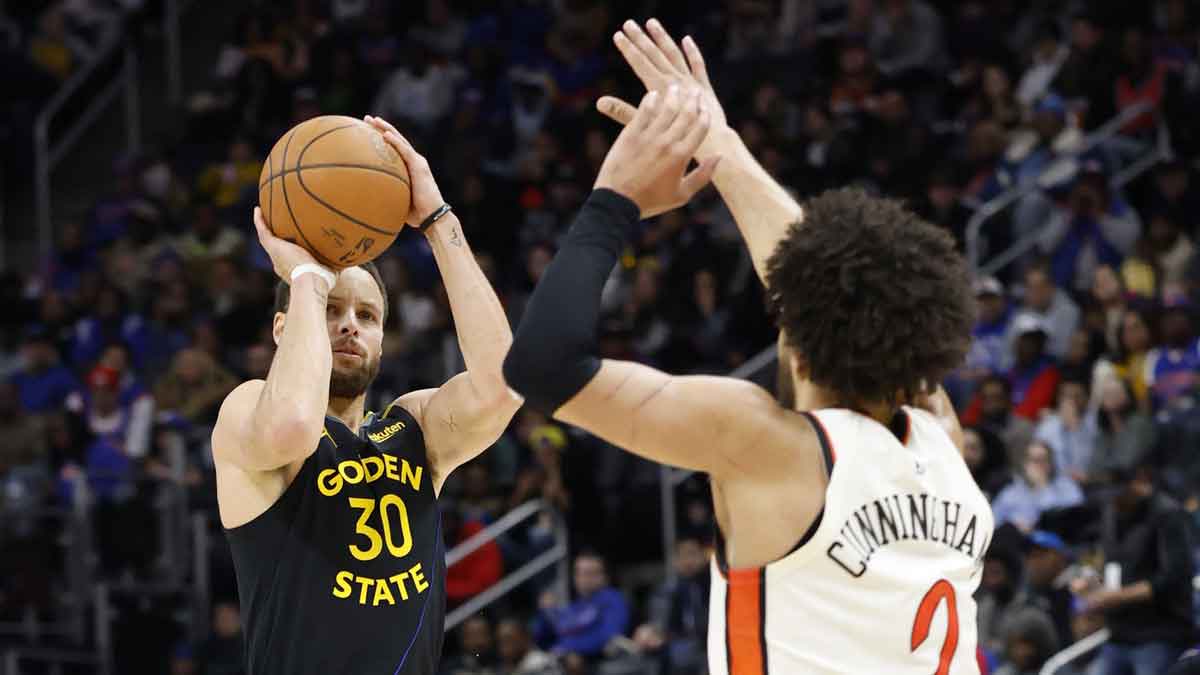 El base de los Warriors, Stephen Curry (30), dispara por encima de Cade Cunningham de los Pistons