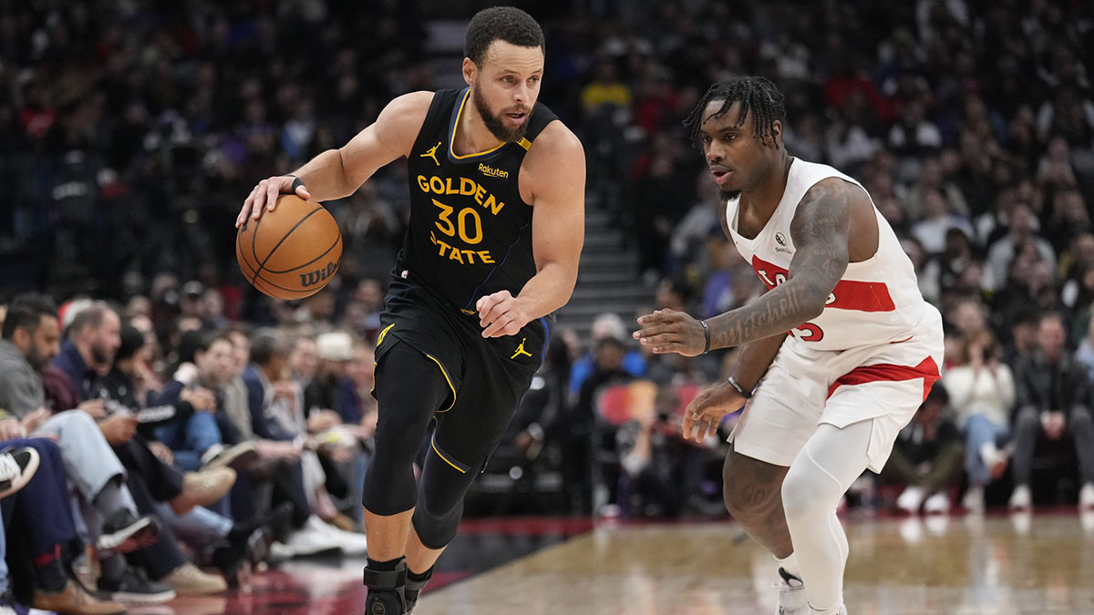 Warriors guard Stephen Curry (30) dribbles past Toronto Raptors guard Davion Mitchell (45) during the second half at Scotiabank Arena