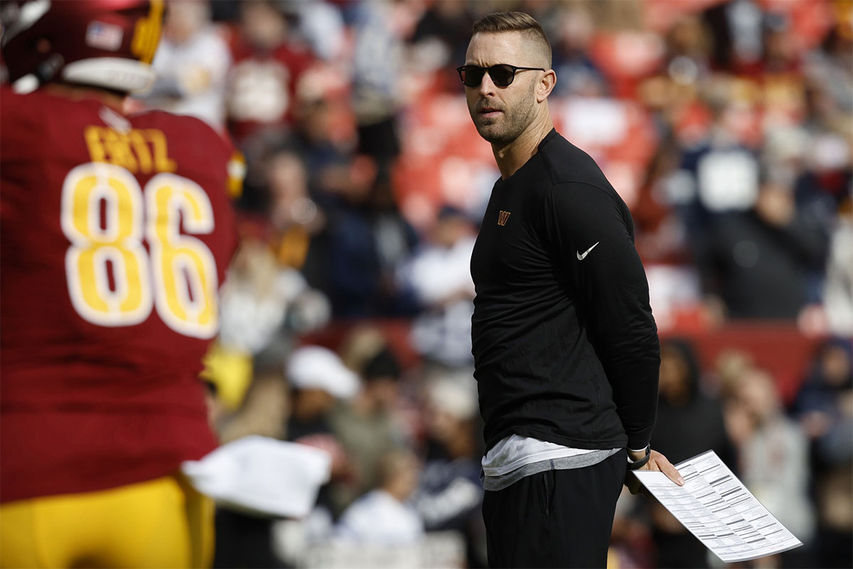 Washington Commanders offensive coordinator Kliff Kingsbury stands on the field during warmup prior to the game against the Dallas Cowboys at Northwest Stadium.