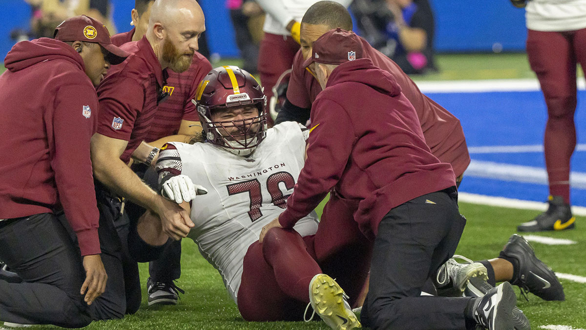 Washington Commanders guard Sam Cosmi (76) received medical on the field after an injury during play against Detroit Lions during the second quarter at Ford Field.
