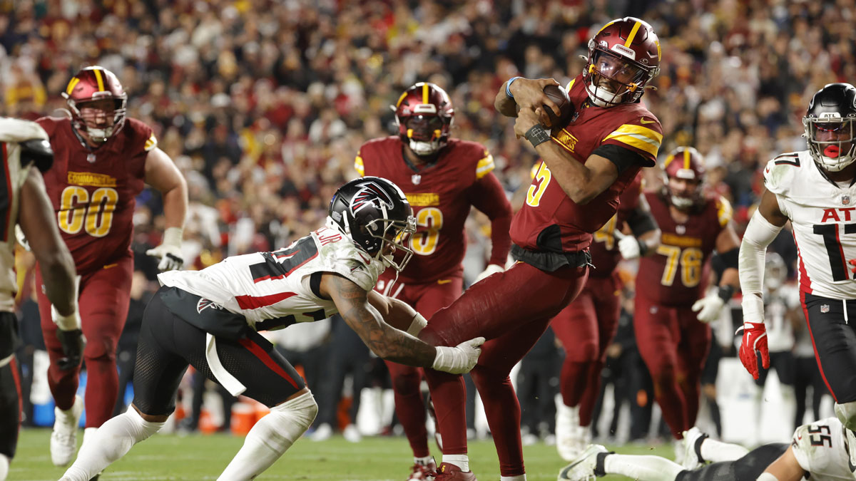 Washington Commanders quarterback Jayden Daniels (5) carries the ball as Atlanta Falcons cornerback A.J. Terrell (24) tackles during the second half at Northwest Stadium.