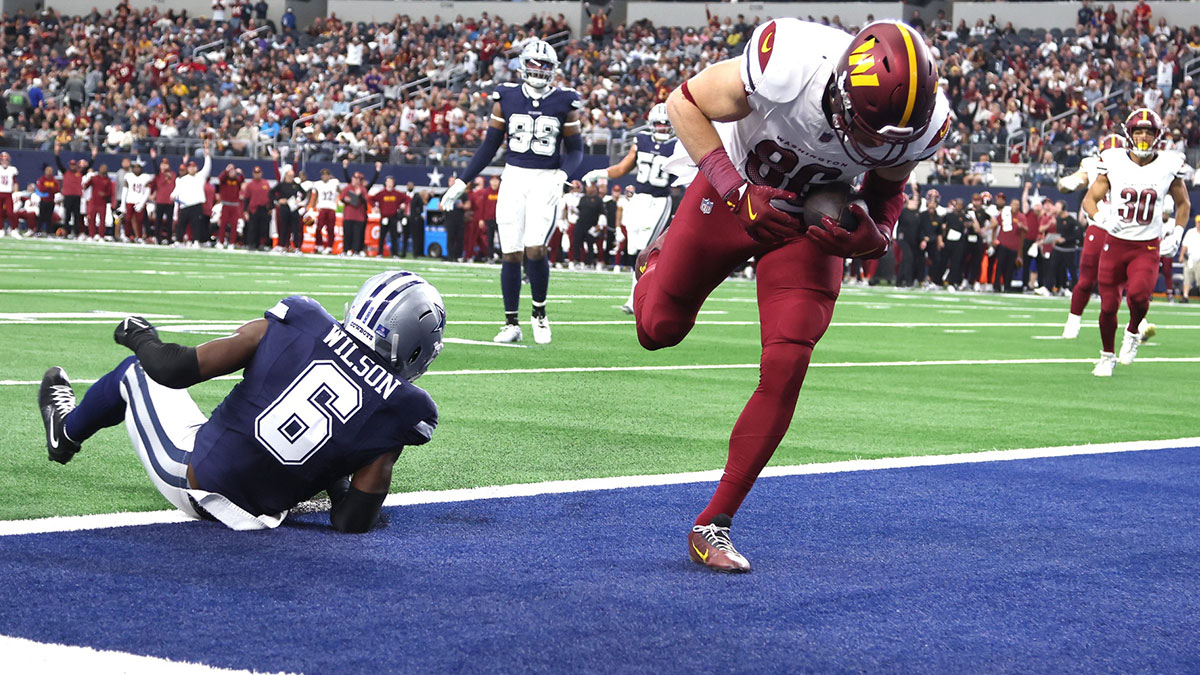 Washington Commanders tight end Zach Ertz (86) catches a touchdown pass against Dallas Cowboys safety Donovan Wilson (6) during the fourth quarter at AT&T Stadium.