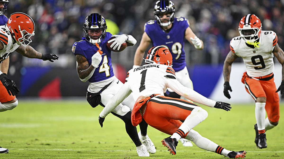 Jan 4, 2025; Baltimore, Maryland, USA; Baltimore Ravens wide receiver Zay Flowers (4) runs the ball during the second quarter as Cleveland Browns safety Juan Thornhill (1) defends at M&T Bank Stadium.