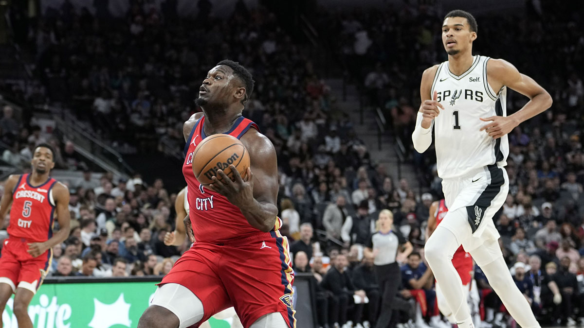 New Orleans Pelicans Zion Williamson (1) drives to the basket past San Antonio Spurs guard Devin Vassell (24) and forward Victor Wembanyama (1) during the first half at Frost Bank Center.