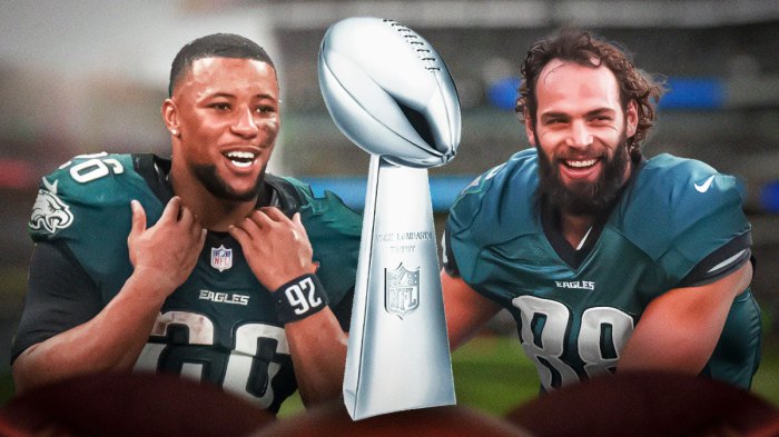 Eagles Dallas Goedert and Saquon Barkley, both smiling/celebrating with the Super Bowl Lombardi Trophy.
