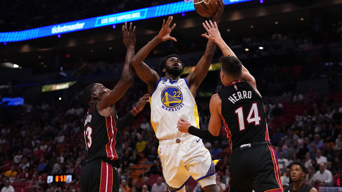 Golden State Warriors forward Andrew Wiggins (22) shoots between Miami Heat guard Tyler Herro (14) and center Bam Adebayo (13) during the first half at FTX Arena.