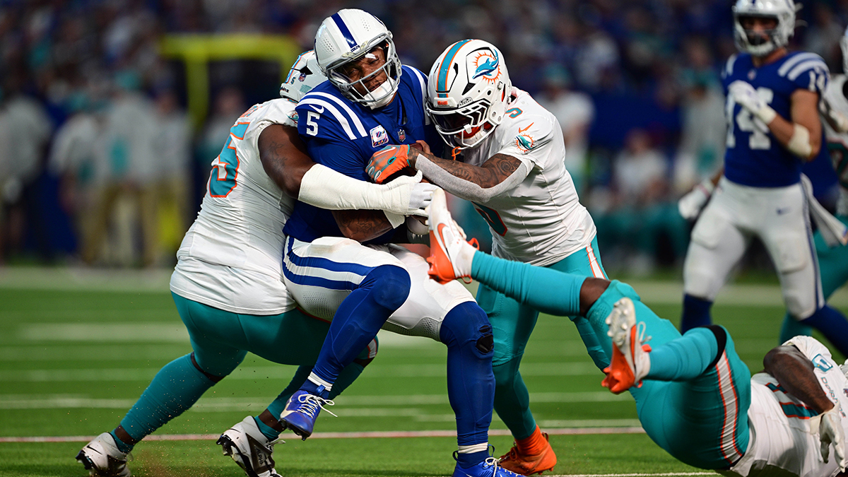 Indianapolis Colts quarterback Anthony Richardson (5) is sacked by Miami Dolphins defensive tackle Benito Jones (95) and cornerback Jalen Ramsey (5) during the second half at Lucas Oil Stadium.
