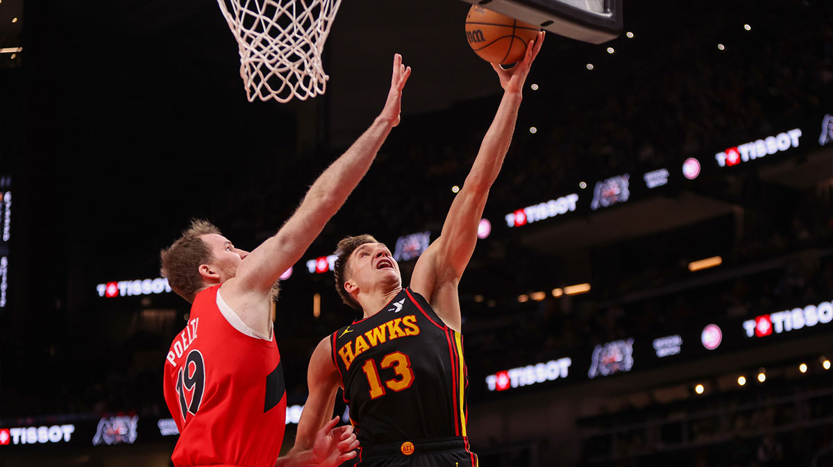 Atlanta Hawks Guard Bogdan Bogdanovic (13) shoots next to Toronto Raptors Center Jakob Poeltl (19) in the second quarter at the State Farm Arena.