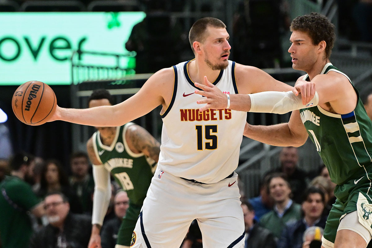 Denver Nuggets center Nikola Jokic (15) looks to pass the ball against Milwaukee Bucks center Brook Lopez (11) in the first quarter at Fiserv Forum. 