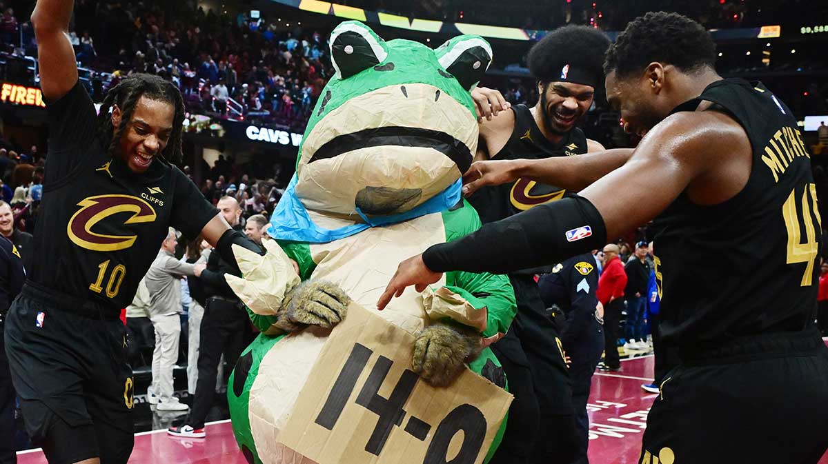 Cleveland Cavaliers guard Darius Garland (10) and center Jarrett Allen (31) and guard Donovan Mitchell (45) celebrate with Moondog after the Cavs defeated the Chicago Bulls and moved to 14-0 on the season at Rocket Mortgage FieldHouse. 