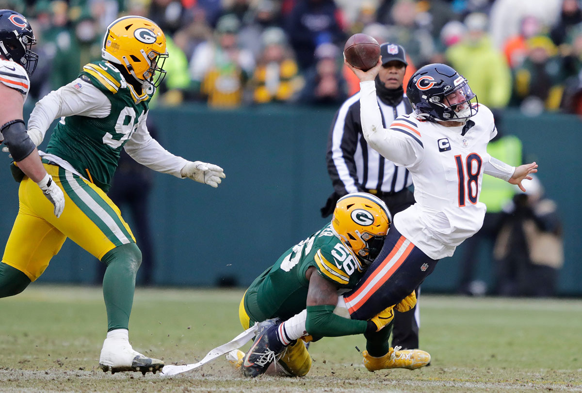 Chicago Medvedi Quarterback Caleb Williams (18) casts incomplete passage while dealing with Green Bay Packers Linebacker Edgerrin Cooper during his football match on Sunday, 5. January 2025. in Lambeau field in Lambeau.