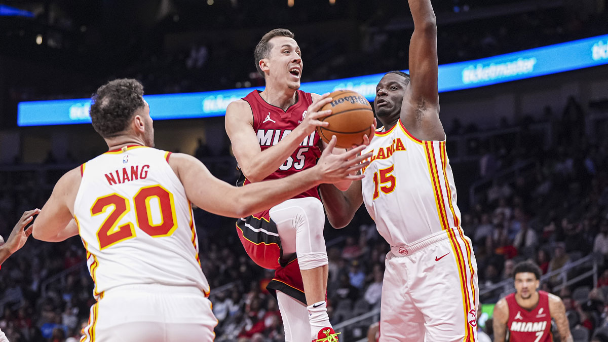Miami Heat forward Duncan Robinson (55) drives to the basket between Atlanta Hawks forward Georges Niang (20) and center Clint Capela (15) during the first half at State Farm Arena.