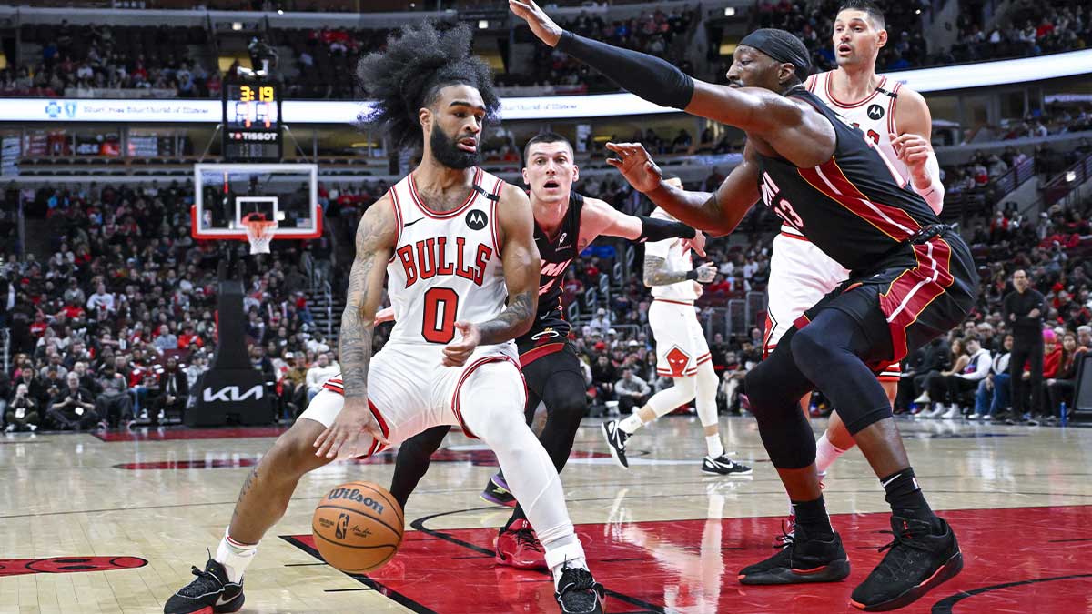 Chicago Bulls Guard Cobi White (0) Moves the ball by Miami Heat Center Bam Adebaiio (13) during the first half to the United Center.