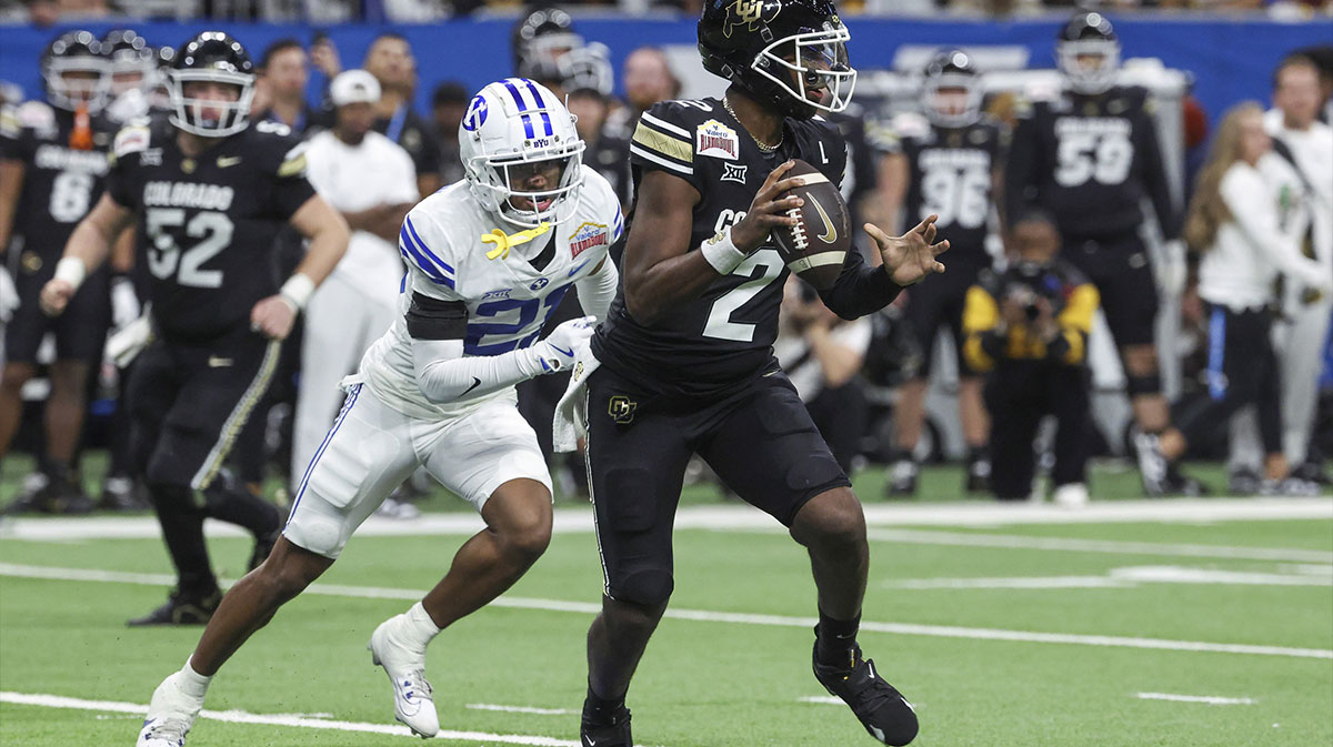 Colorado Buffaloes quarterback Shedeur Sanders (2) runs with the ball as Brigham Young Cougars cornerback Evan Johnson (21) attempts to make a tackle during the third quarter at Alamodome.