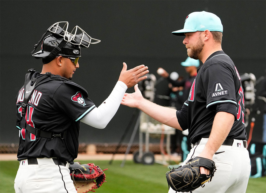 Arizona Diamondbacks catcher Gabriel Moreno greets new pitcher Corbin Burnes after throwing in the bullpen on the first day of spring training practice