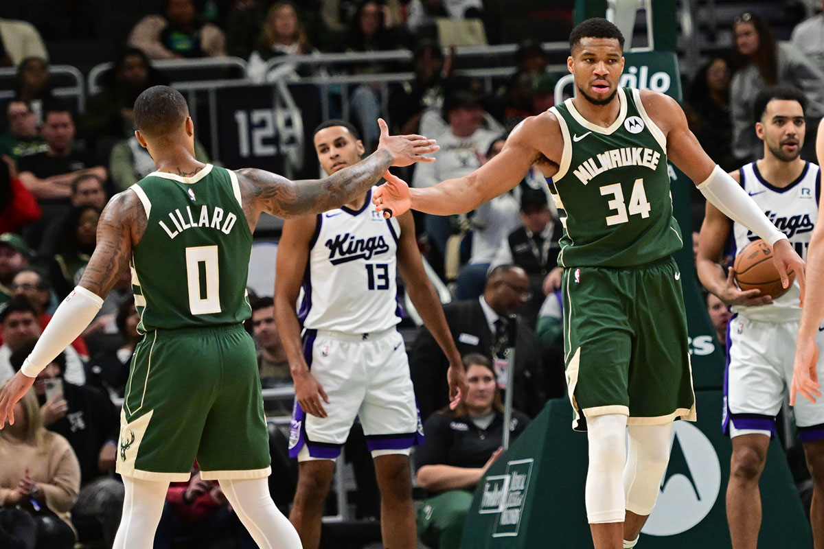 Milwaukee Bucks forward Giannis Antetokounmpo (34) reacts with guard Damian Lillard (0) after scoring a basket in the second quarter against the Sacramento Kings at Fiserv Forum.