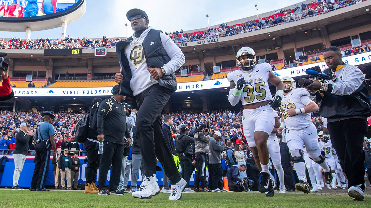 Colorado head coach Deion Sanders leads his team on to the field against the Kansas Jayhawks at GEHA Field at Arrowhead Stadium.