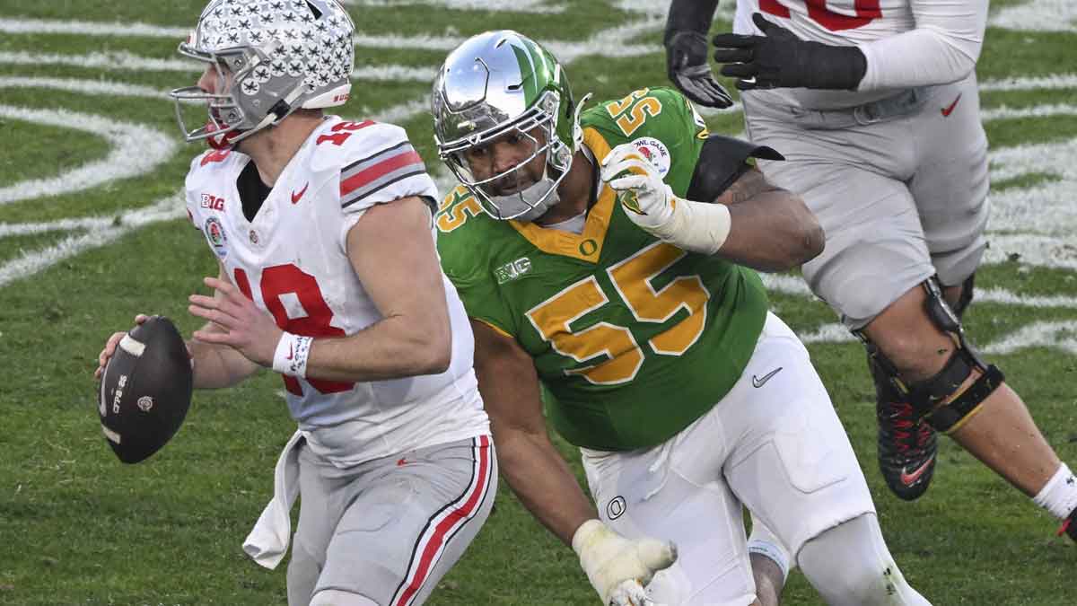 Ohio State Buckeyes quarterback Will Howard (18) looks for an open receiver as Oregon Ducks defensive lineman Derrick Harmon (55) closes in durigt the third quarter at Rose Bowl Stadium. Mandatory Credit: Robert Hanashiro-Imagn Images