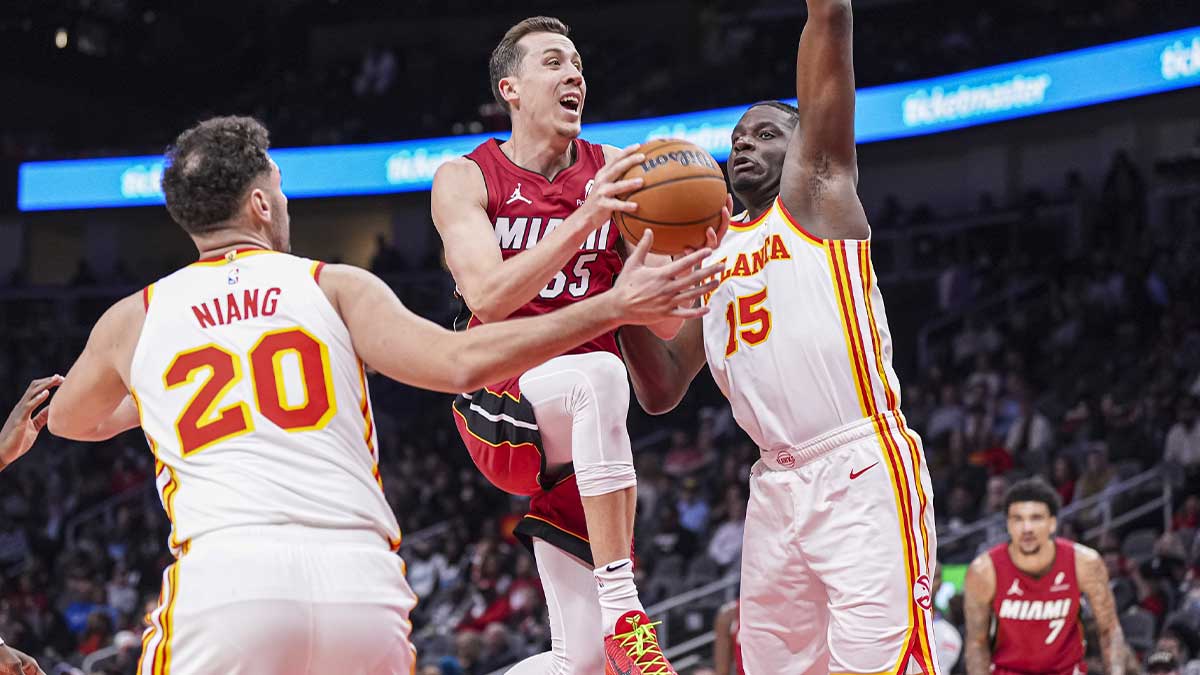 The Miami Heat Duncan Robinson striker (55) goes to the basket between the Atlanta Hawks striker Georges Niang (20) and the Center Clint Capela (15) during the first half at State Farm Arena.