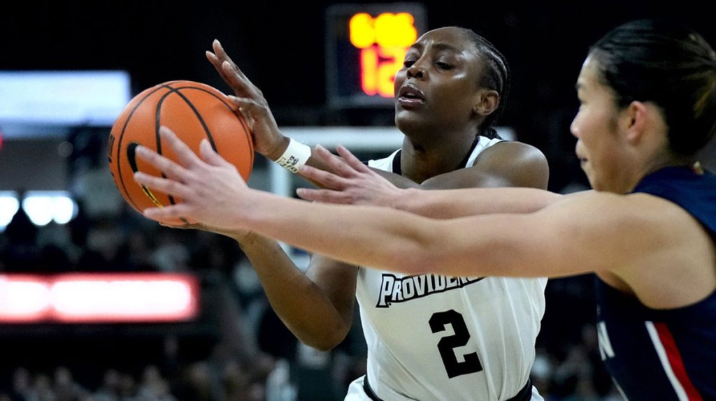 Friar guard Grace Efosa fires off a pass under pressure from Huskies defender Kaitlyn Chen.