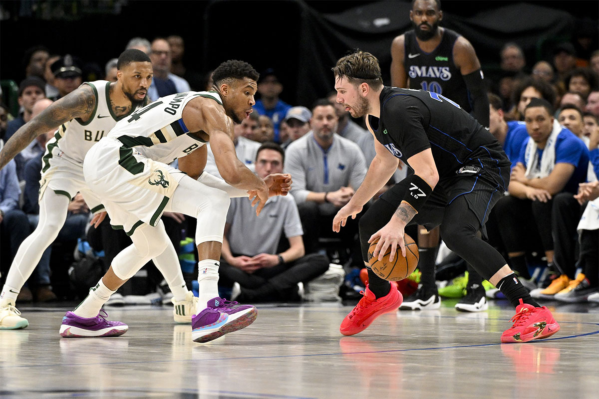 Dallas Mavericks Guard Luka Doncic (77) Looks like Milvaukee Bucks Guard Damian Lillard (0) and Giannis Antetokounpu (34) during the second half in the center of American Airlines.