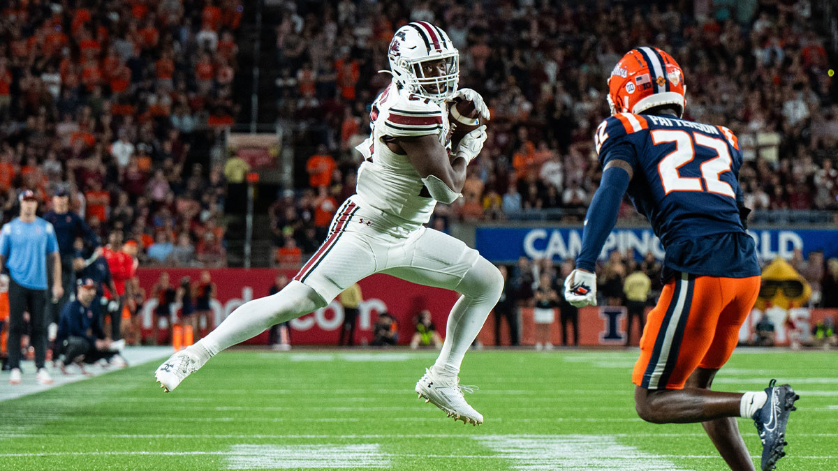 Dec 31, 2024; Orlando, FL, USA; South Carolina Gamecocks running back Oscar Adaway III (27) makes the catch against Illinois Fighting Illini defensive back Kaleb Patterson (22) in the fourth quarter at Camping World Stadium. Mandatory Credit: Jeremy Reper-Imagn Images