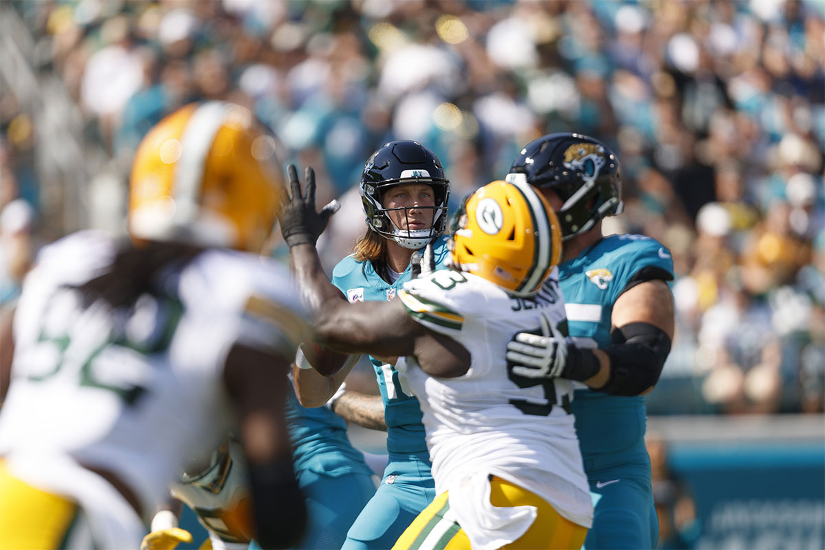 Jacksonville Jaguars quarterback Trevor Lawrence (16) looks for a pass under pressure from Green Bay Packers defensive lineman TJ Slaton (93) during the first quarter at EverBank Stadium.