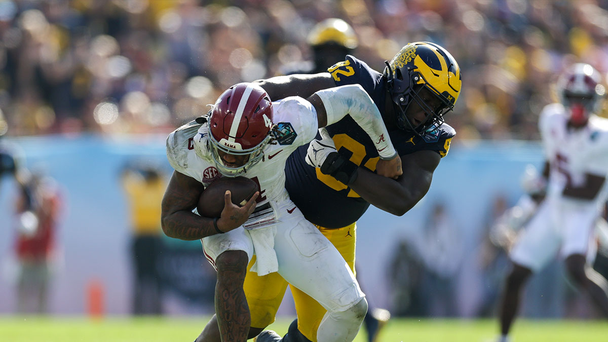 Alabama Crimson Tide quarterback Jalen Milroe (4) is sacked by Michigan Wolverines defensive lineman Ike Iwunnah (92) in the third quarter during the ReliaQuest Bowl at Raymond James Stadium