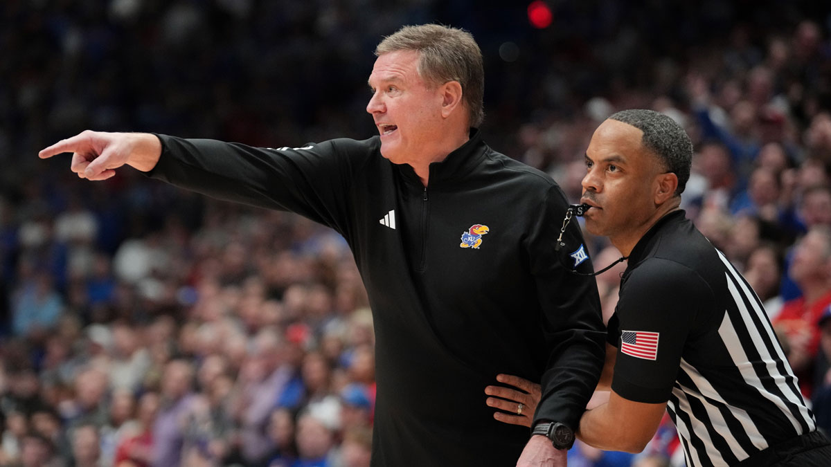 An official restrains Kansas Jayhawks head coach Bill Self against the Houston Cougars during overtime at Allen Fieldhouse.