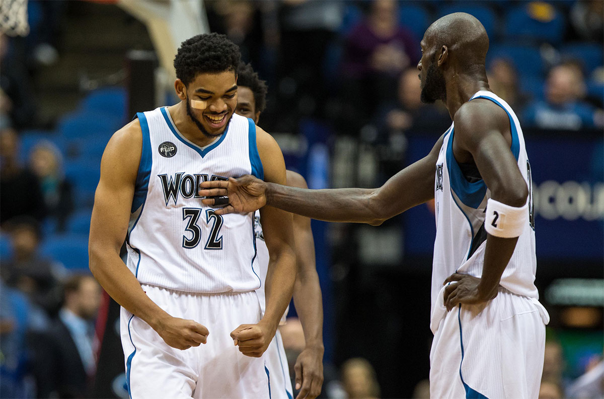 Minnesota Timberwolves center Karl-Anthony Towns (32) celebrates with forward Kevin Garnett (21) against the Los Angeles Clippers at Target Center. The Clippers defeated the Timberwolves 110-106. 