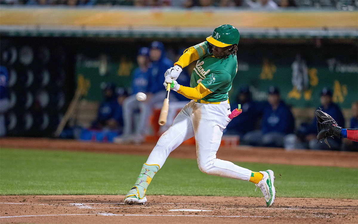 Oakland Athletics right fielder Lawrence Butler (4) hits a double against the Texas Rangers during the third inning at Oakland-Alameda County Coliseum.