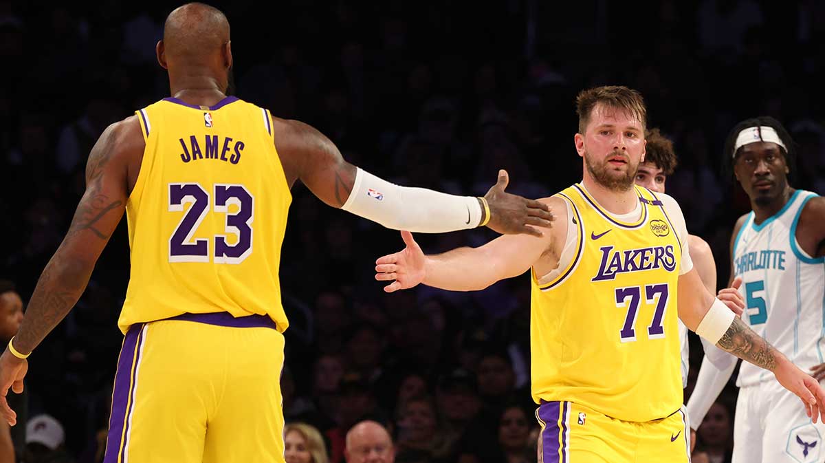 Los Angeles Lakers forward LeBron James (23) and guard Luka Doncic (77) celebrate after a play during the third quarter against the Charlotte Hornets at Crypto.com Arena.