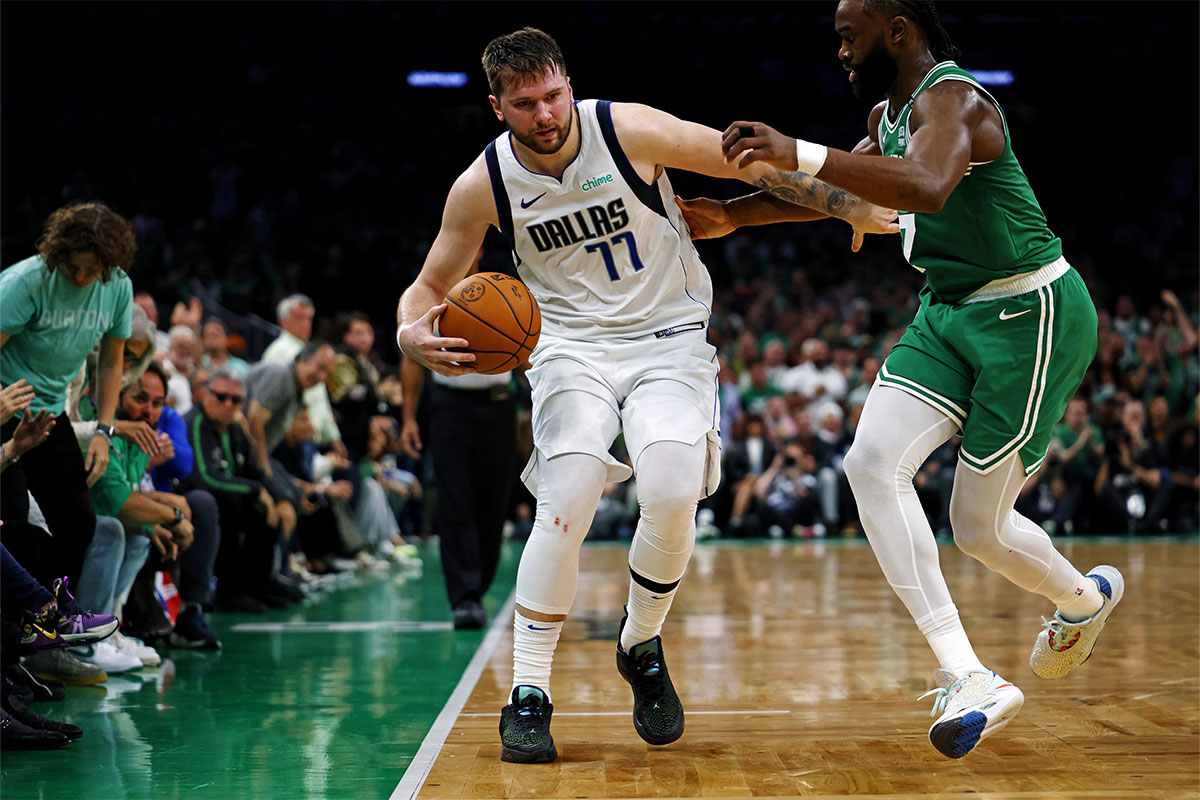 Dallas Mavericks guard Luka Doncic (77) handles the ball against Boston Celtics guard Jaylen Brown (7) in game five of the 2024 NBA Finals at TD Garden. 