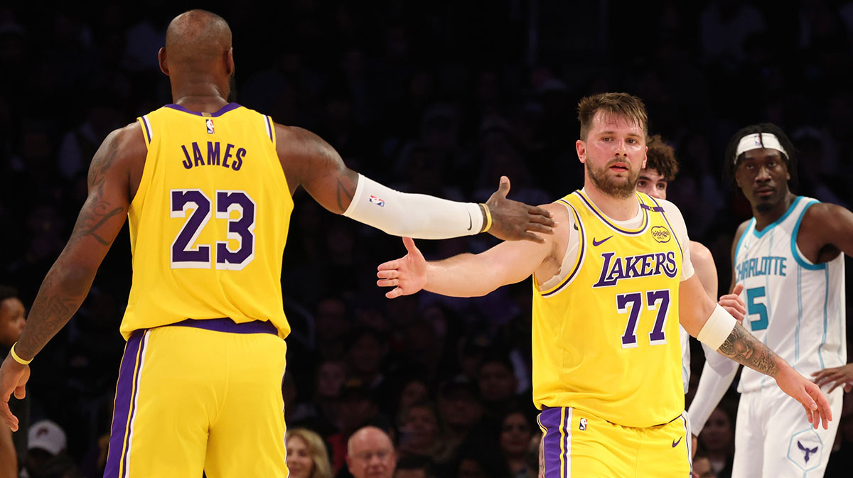 Los Angeles Lakers forward LeBron James (23) and guard Luka Doncic (77) celebrate after a play during the third quarter against the Charlotte Hornets at Crypto.com Arena.