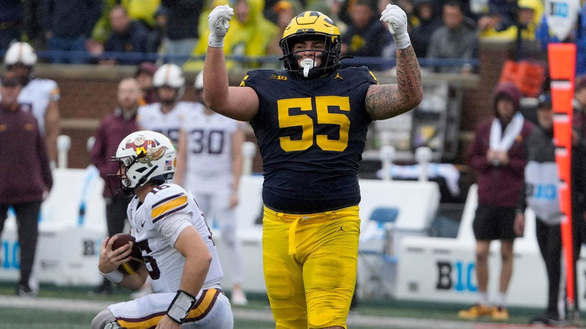 Michigan defensive lineman Mason Graham celebrates after sacking Minnesota quarterback Max Brosmer, in the background, during first-half action between Michigan and Minnesota at Michigan Stadium