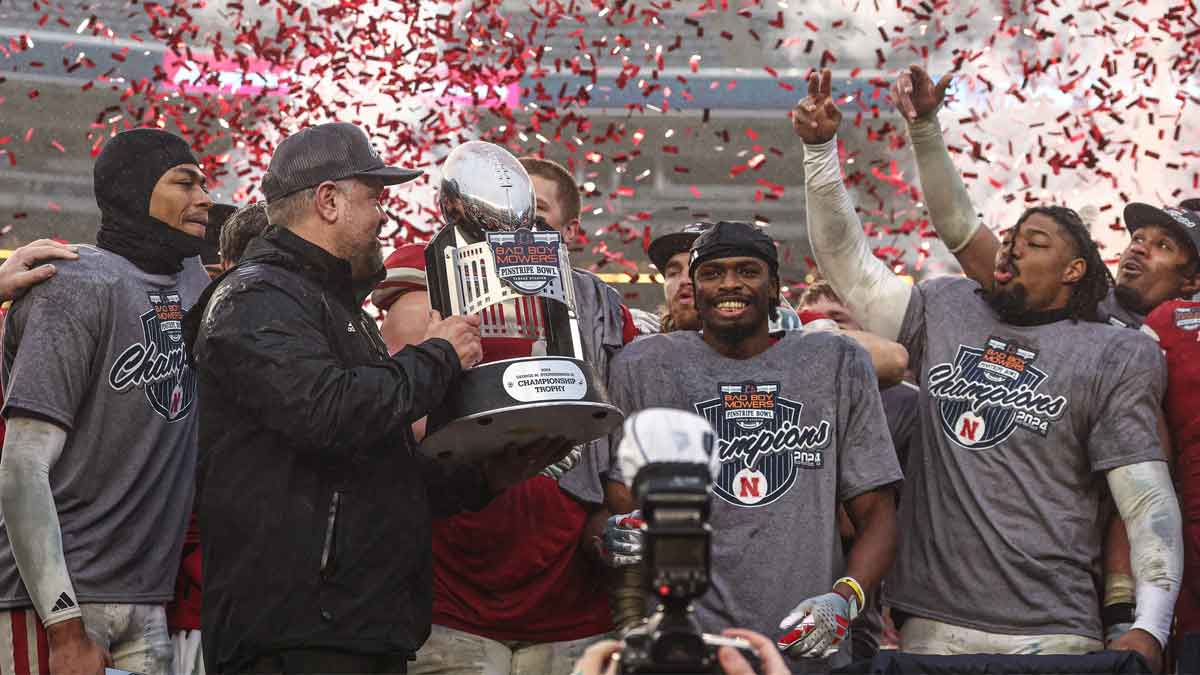 Nebraska Cornhuskers head coach Matt Rhule holds the championship trophy as Cornhuskers players celebrate after the game against the Boston College Eagles at Yankee Stadium.