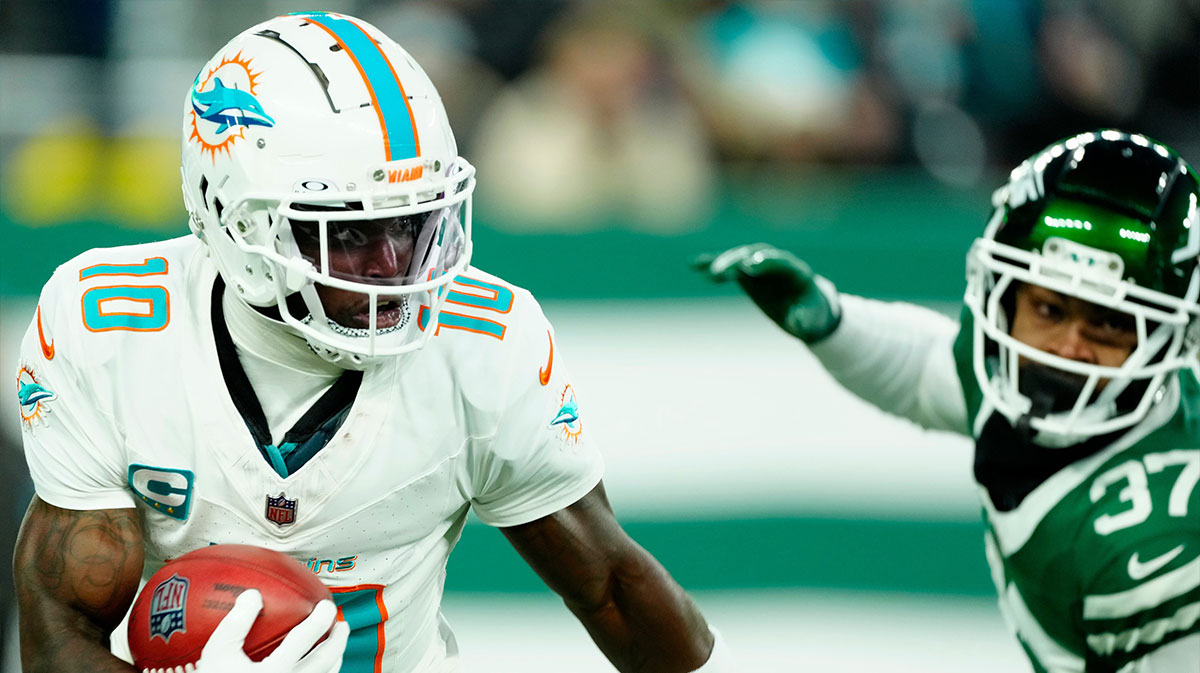 Miami Dolphins wide receiver Tyreek Hill (10) runs with the ball past New York Jets cornerback Qwan'tez Stiggers (37), Sunday January 5, 2025, in East Rutherford.