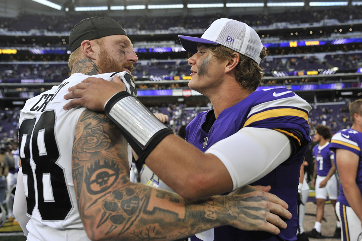 Minnesota Vikings quarterback J.J. McCarthy (9) and Las Vegas Raiders defensive end Maxx Crosby (98) react after the game at U.S. Bank Stadium.