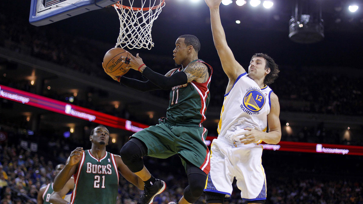 Milwaukee Bucks guard Monta Ellis (11) makes a shot under the reach of Golden State Warriors center Andrew Bogut (12) in the second quarter at ORACLE arena.