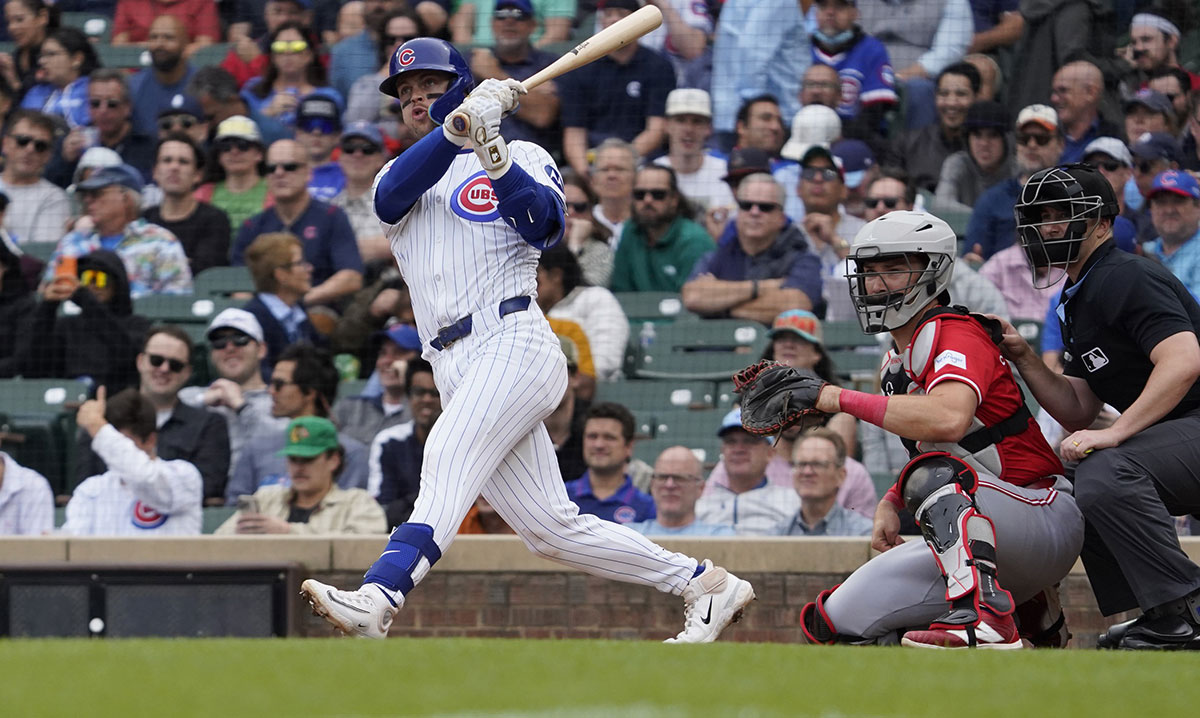 Chicago Cubs second baseman Nico Hoerner (2) hits a double against the Cincinnati Reds during the fifth inning at Wrigley Field.