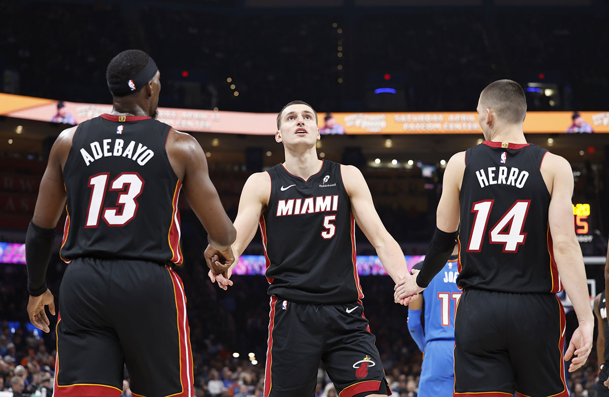 Miami Heat forward Nikola Jovic (5) celebrates with teammates center Bam Adebayo (13) and guard Tyler Herro (14) after a play against the Oklahoma City Thunder during the second quarter at Paycom Center.