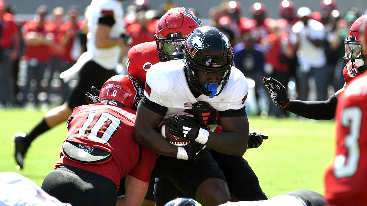 Northern Illinois Huskies Antario Brown (1) runs the ball against North Carolina State Wolfpack linebacker Caden Fordham (10) during the first half at Carter-Finley Stadium.