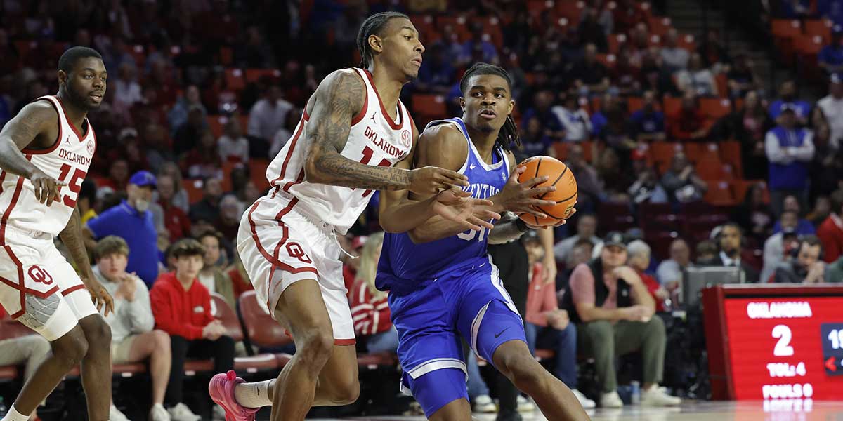 Kentucky Wildcats guard Otega Oweh (00) drives to the basket around Oklahoma Sooners forward Jalon Moore (14) during the first half at Lloyd Noble Center.