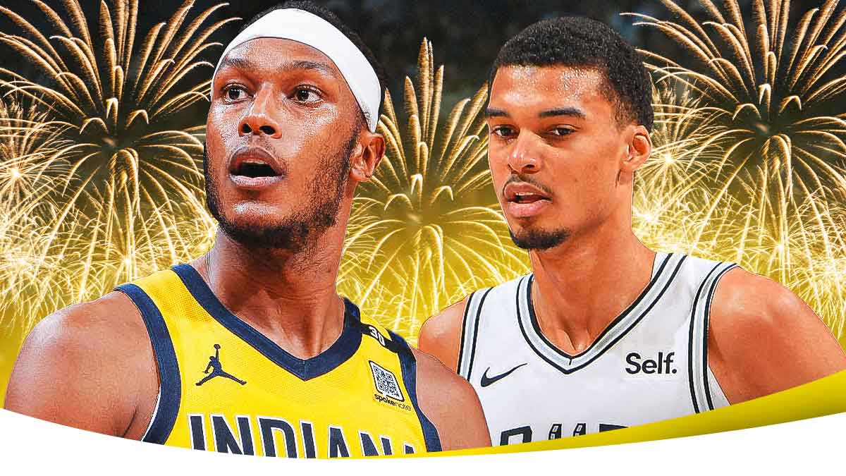 Myles Turner and Victor Wembanyama with fireworks in the background.