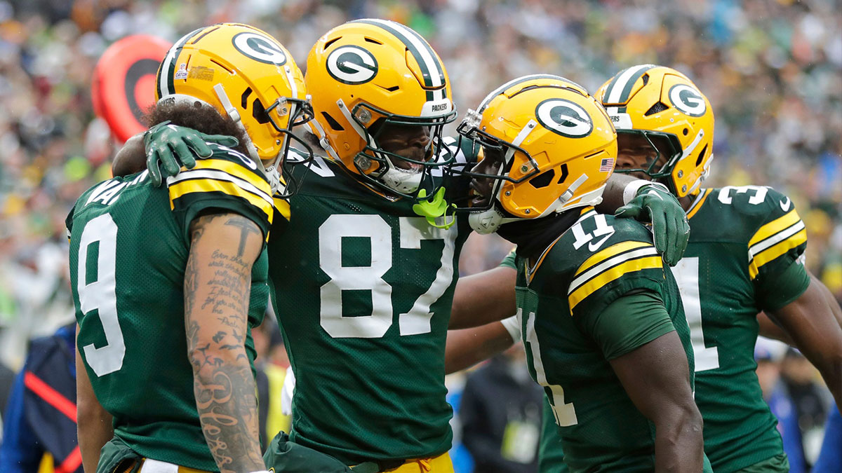 Green Bay Packers wide receiver Romeo Doubs (87) celebrates scoring a touchdown with wide receiver Christian Watson (9), wide receiver Jayden Reed (11) and running back Emanuel Wilson (31) against the Arizona Cardinals during their football game Sunday, October 13, 2024, at Lambeau Field in Green Bay, Wisconsin.