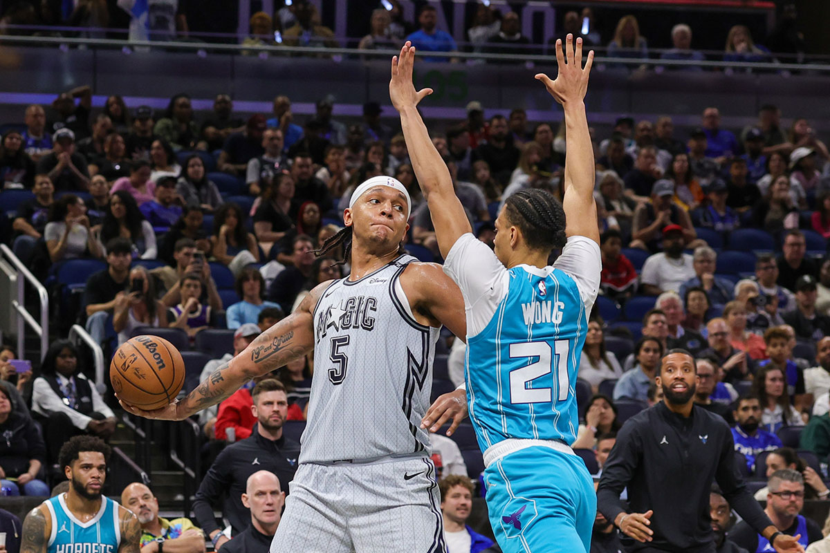 Orlando Magic Forward Paolo Banchero (5) passes the ball through Charlotte Hornets Guard Isaiah Vong (21) during the second half in the Kia Center.