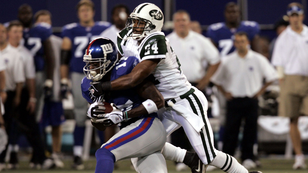 Giants Plaxico Burress is taken down by Jets Ty Law after a first quarter catch at the Meadowlands Aug. 26, 2005. The Giants won the game 15-14.