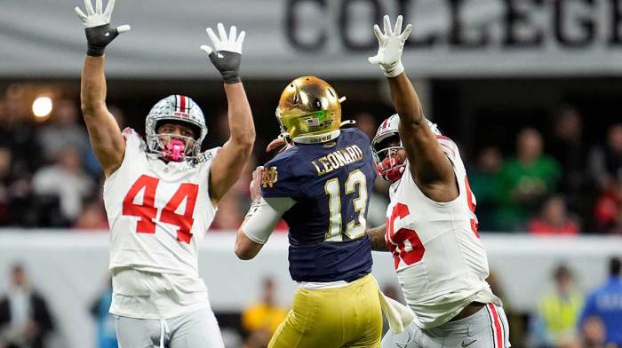 Notre Dame Fighting Irish quarterback Riley Leonard (13) throws the ball against Ohio State Buckeyes defensive end JT Tuimoloau (44) and Ohio State Buckeyes defensive end Eddrick Houston (96) in the fourth quarter during the College Football Playoff National Championship at Mercedes-Benz Stadium in Atlanta on January 20, 2025.